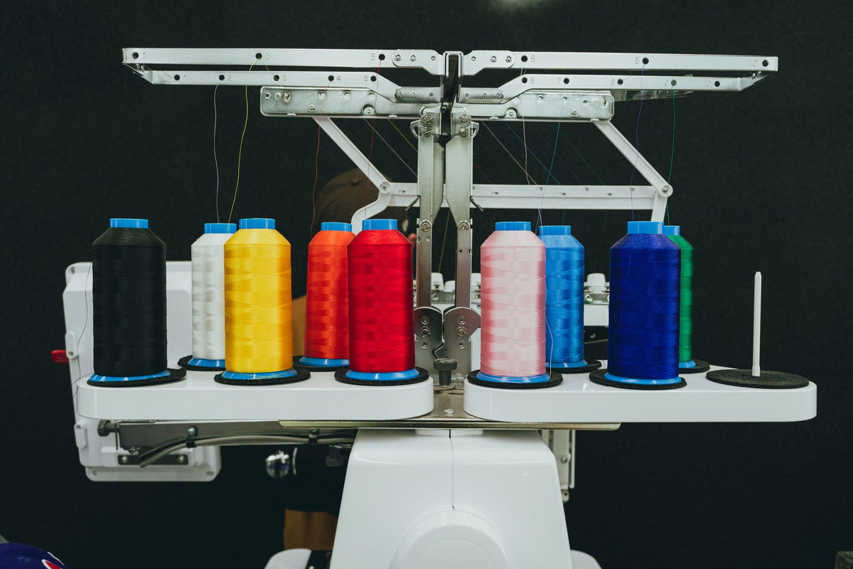Colorful thread spools on an industrial embroidery machine thread tree